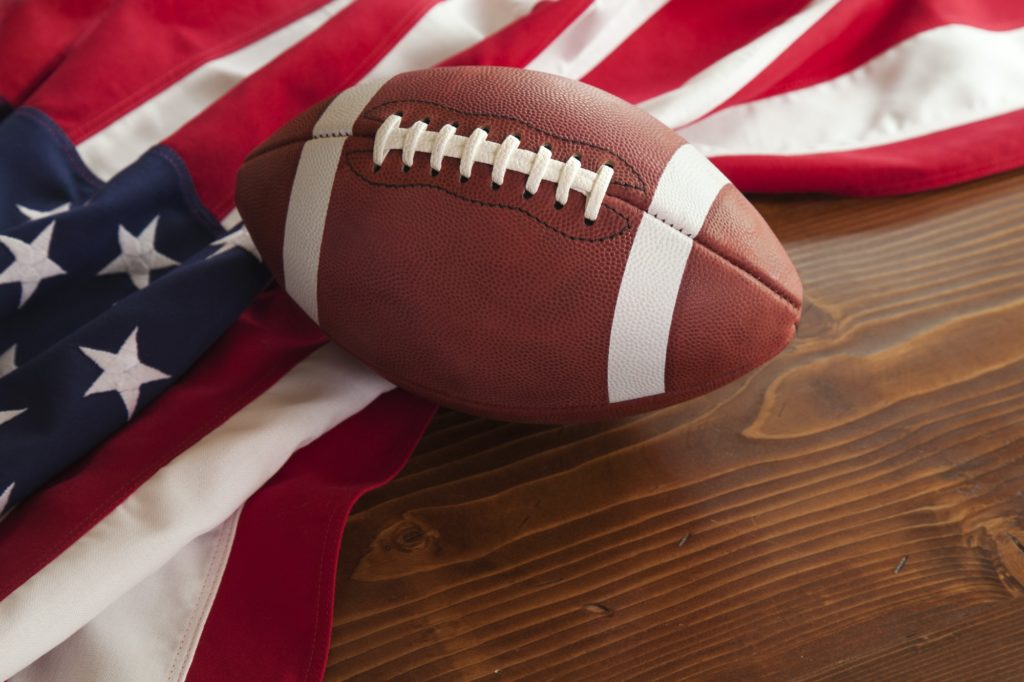 Football and American Flag on Wood Surface