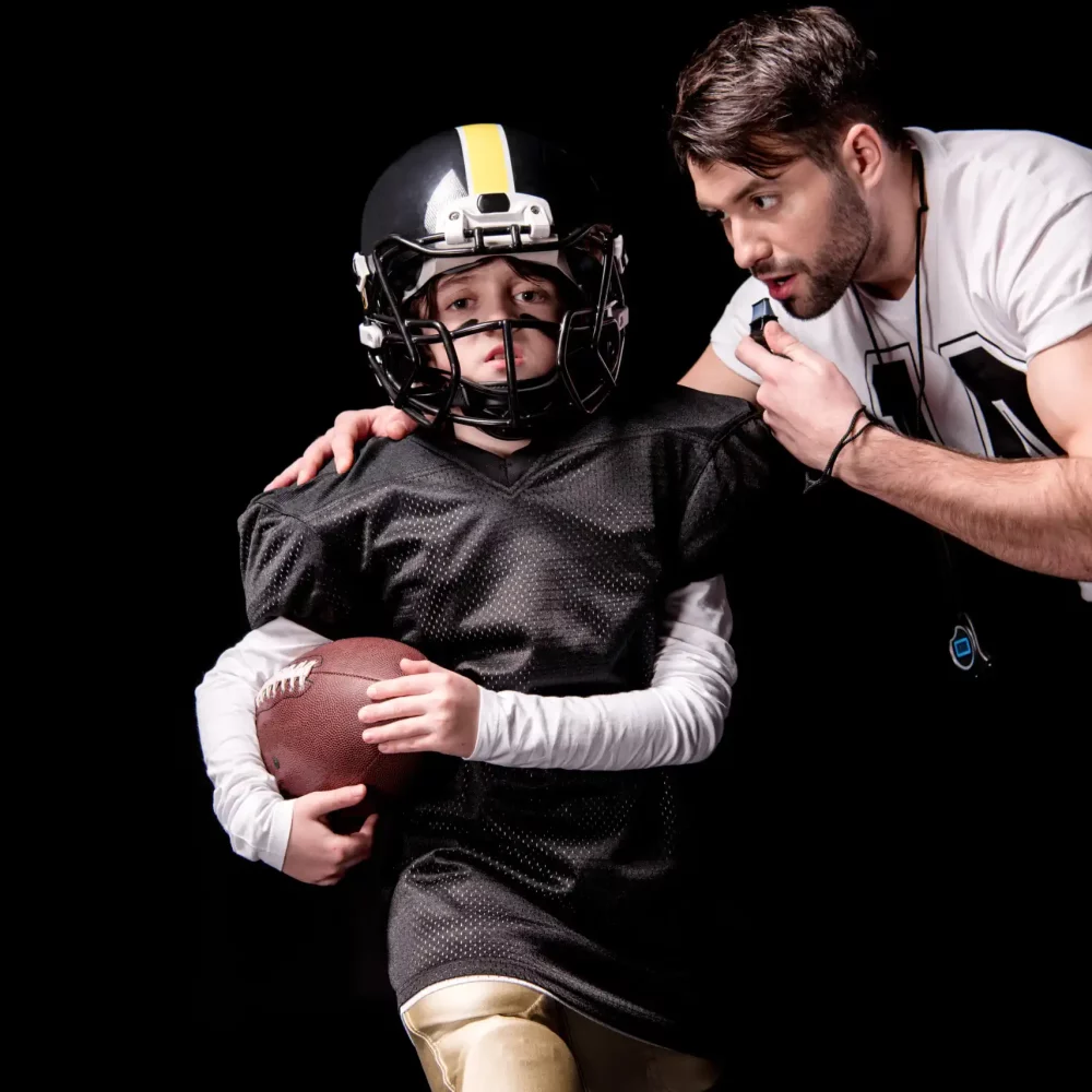 coach-looking-at-boy-american-football-player-runn-2021-08-29-10-18-16-utc-scaled